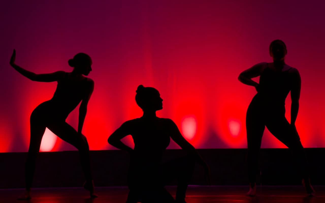 Bailarines en silueta con iluminación roja
